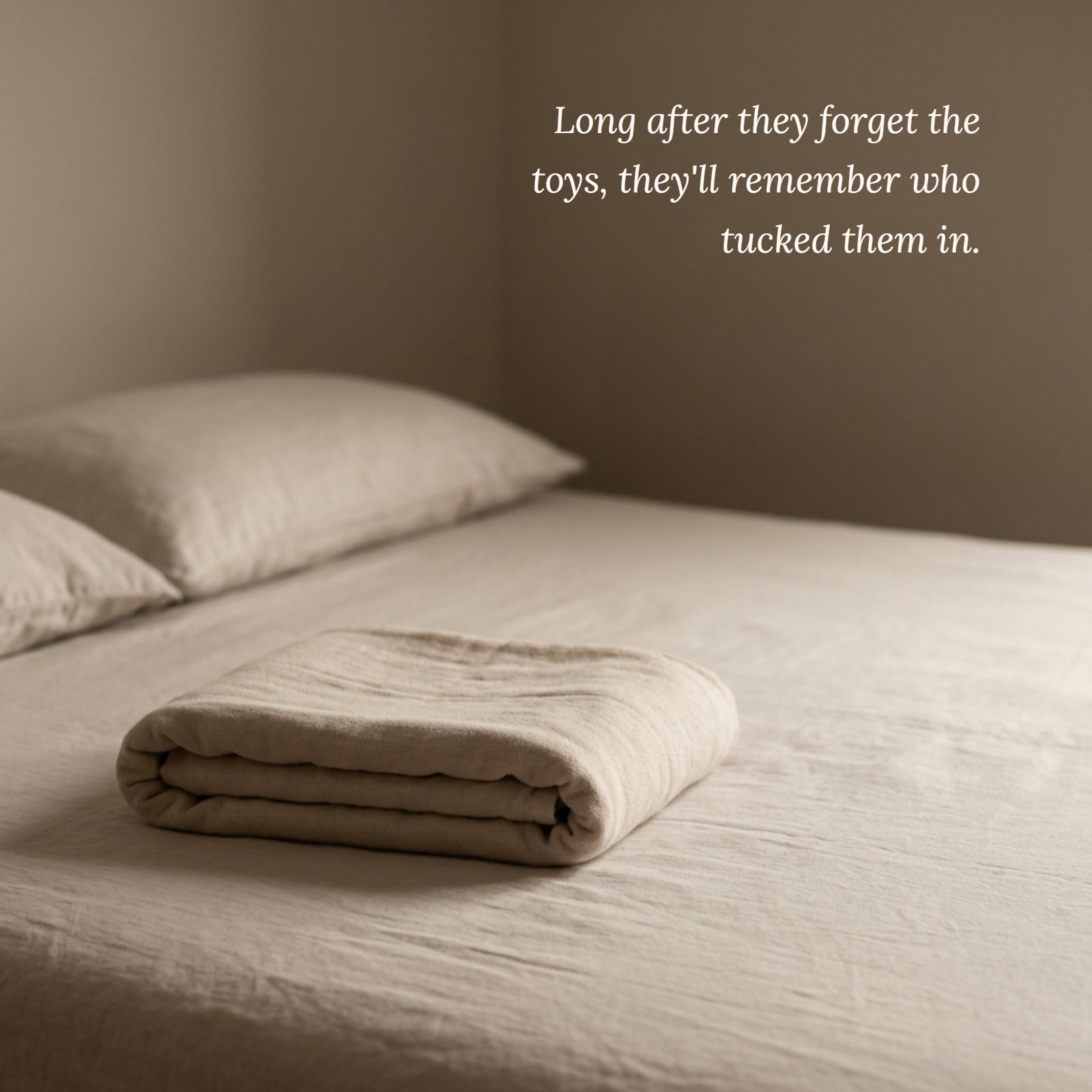 A minimalist photo of a single soft child's blanket neatly folded on a plain bed in warm, dim light, with the quote text "Long after they forget the toys, they'll remember who tucked them in" written in an elegant font.