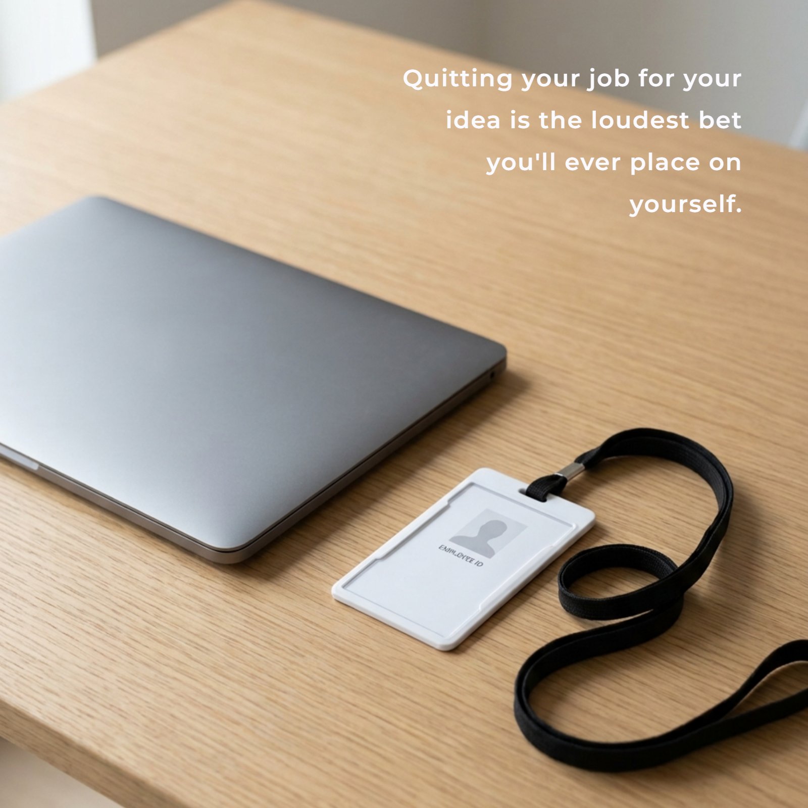 A minimalist desk with a closed laptop and an empty ID badge holder. The quote 'Quitting your job for your idea is the loudest bet you'll ever place on yourself.' is overlaid on the image.