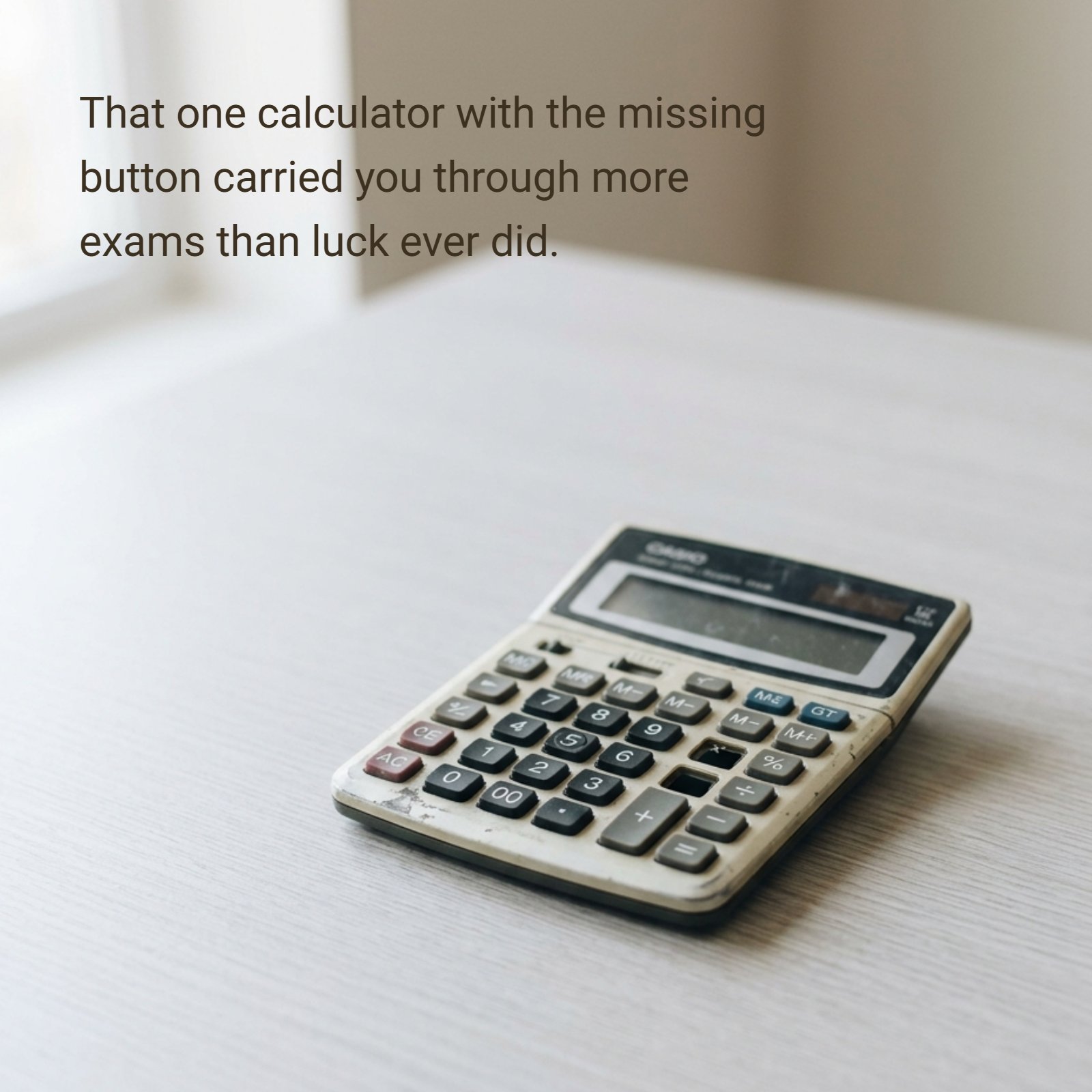 Minimalist 4:5 photograph of a single worn calculator with a missing button resting on a plain desk under soft neutral light.