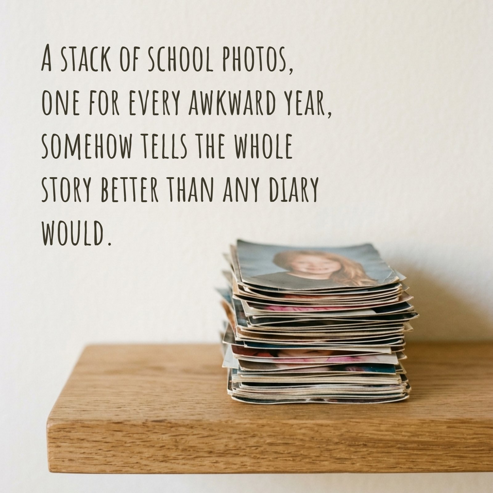 A minimalist photograph showing a single stack of old, physical school photos resting on a plain wooden shelf, with a soft background. The quote text 'A stack of school photos, one for every awkward year, somehow tells the whole story better than any diary would.' is overlaid on the negative space.
