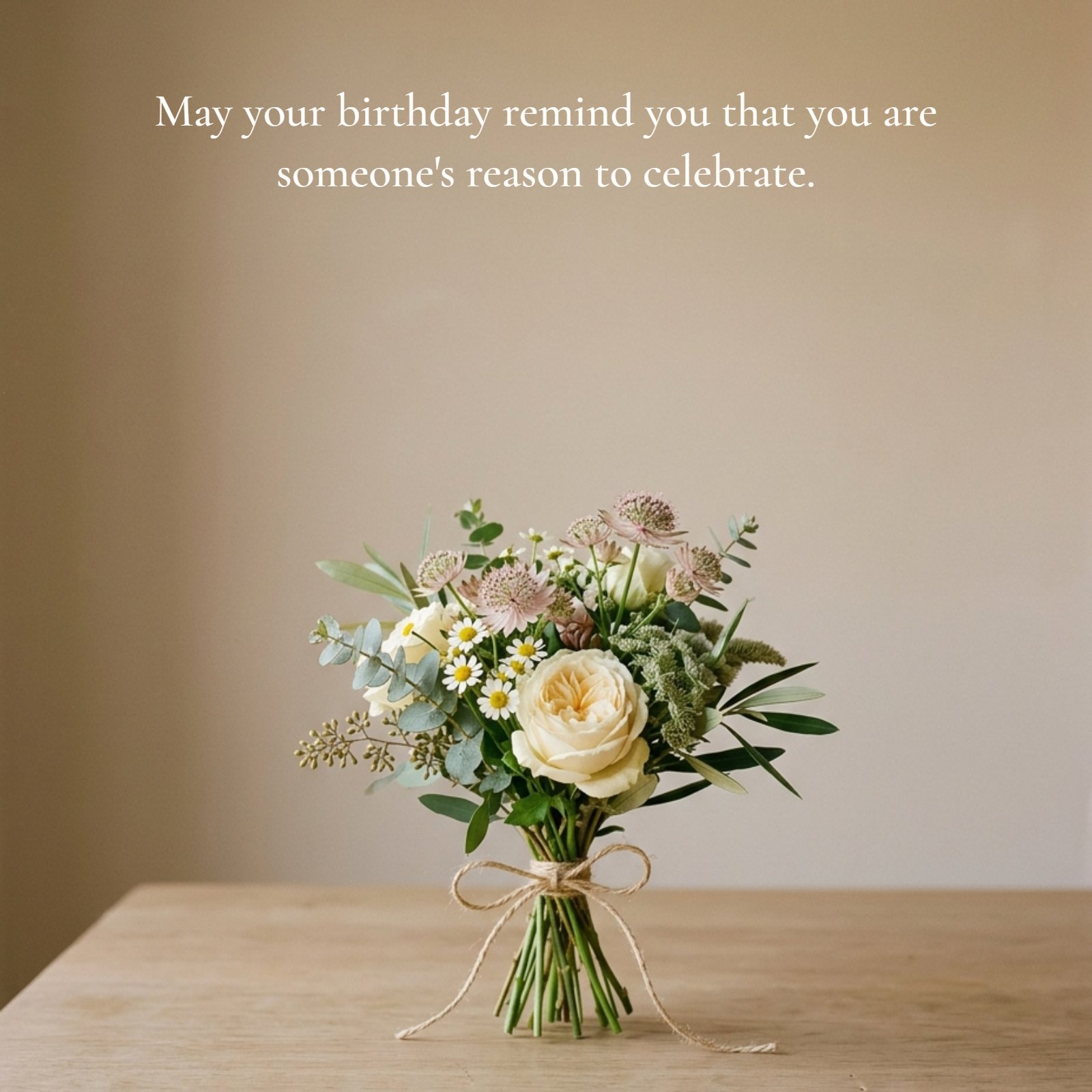A minimalist photo showing a single small flower bouquet with white roses and greenery on a wooden table, featuring the quote: May your birthday remind you that you are someone's reason to celebrate.
