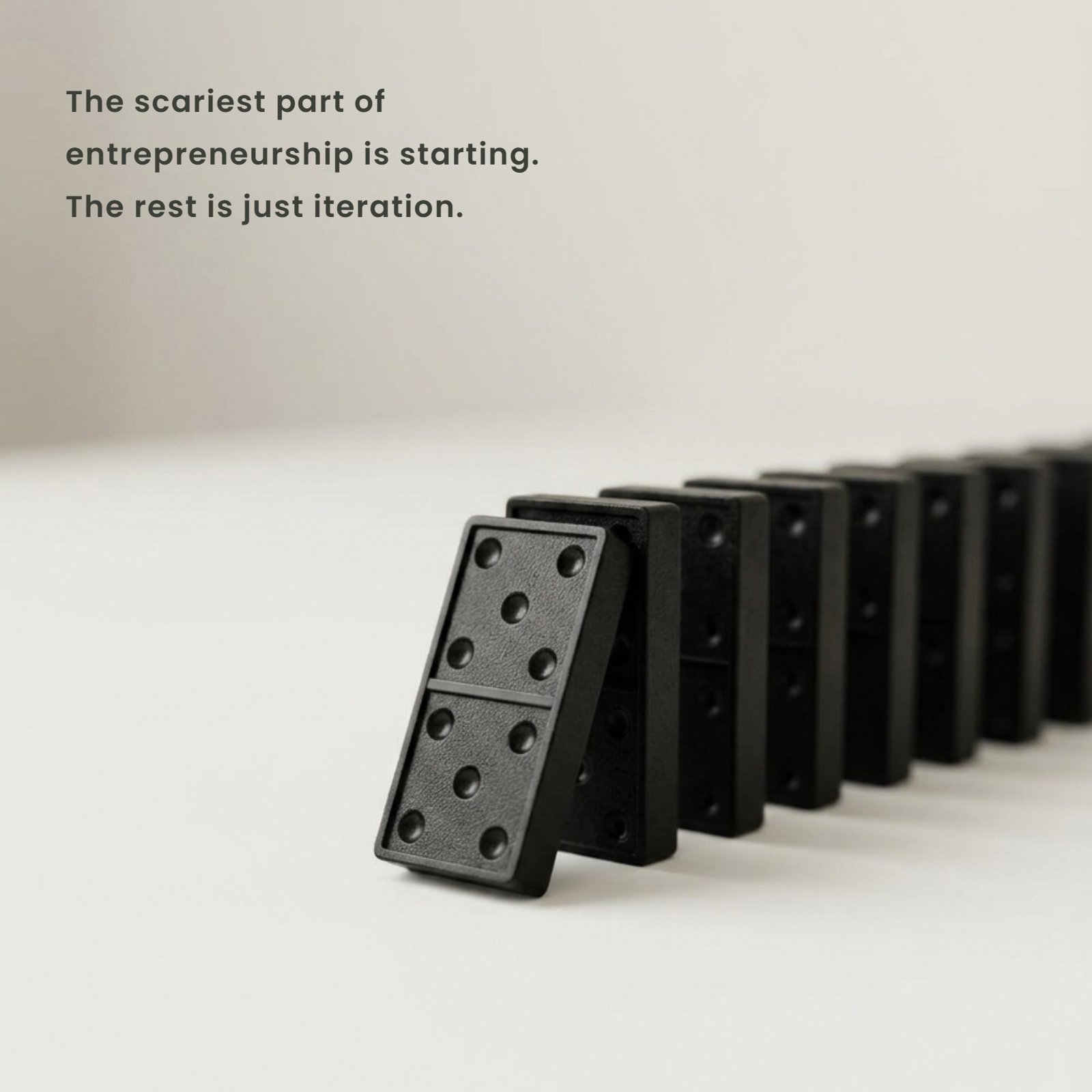A black domino stands at the front of a line, representing the first step in a business journey.