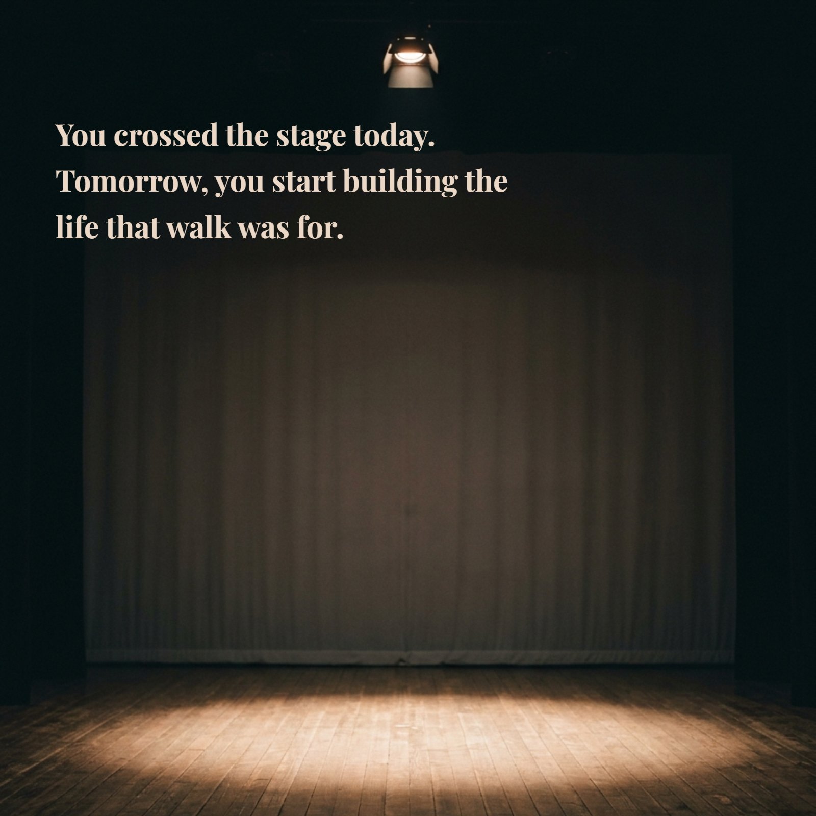 A photo of an empty wooden stage with a single warm spotlight and a neutral background, featuring the quote: You crossed the stage today. Tomorrow, you start building the life that walk was for.