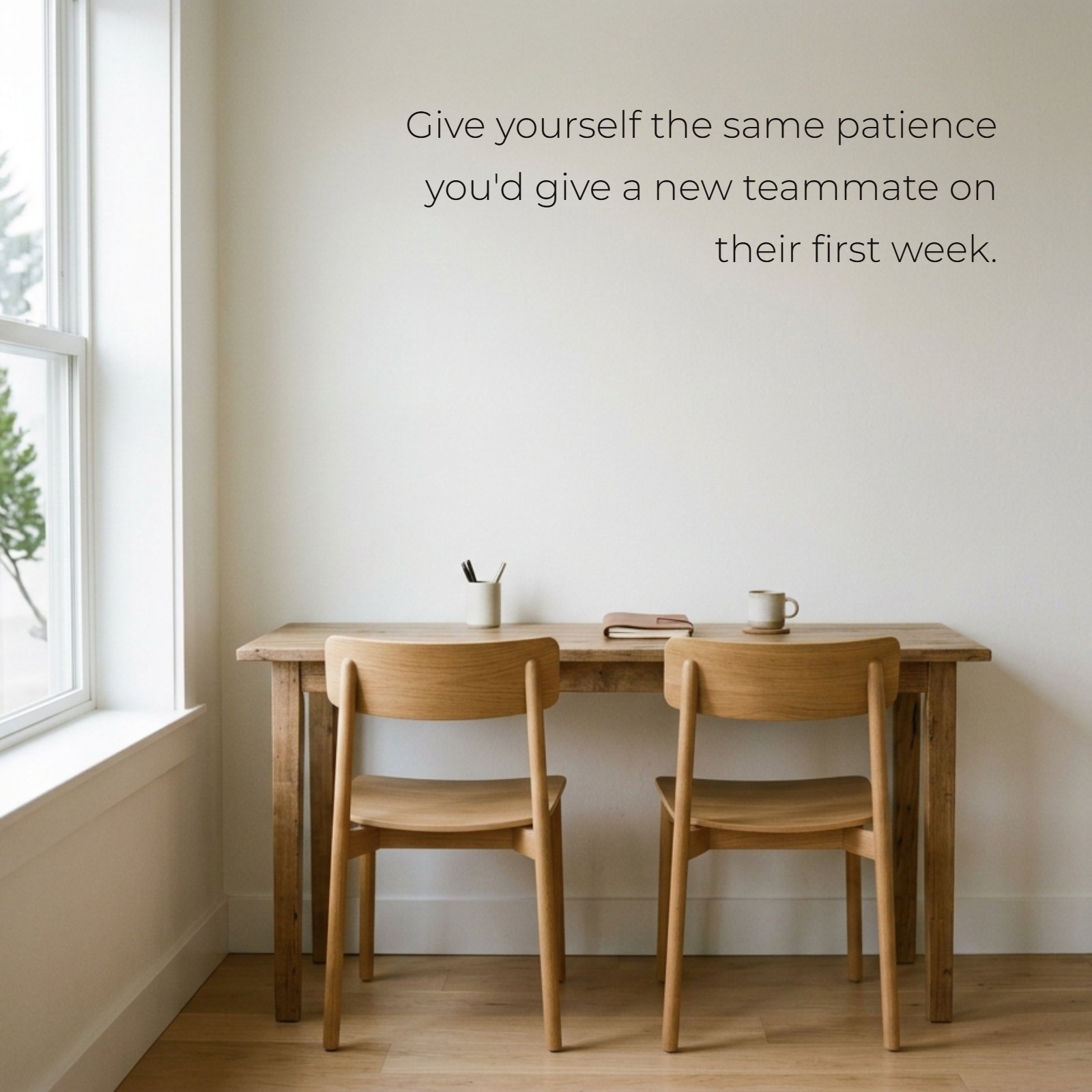 A minimalist image of two light wood office chairs at a desk with the text "Give yourself the same patience you'd give a new teammate on their first week."