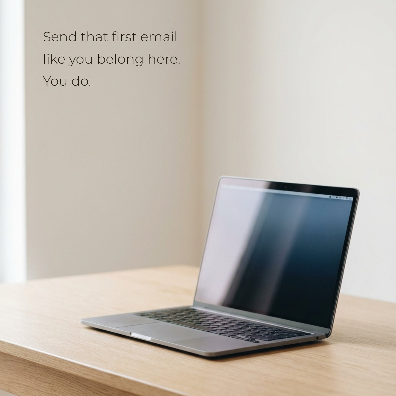 A clean photograph of an open laptop on a wooden desk with a quote: "Send that first email like you belong here. You do."