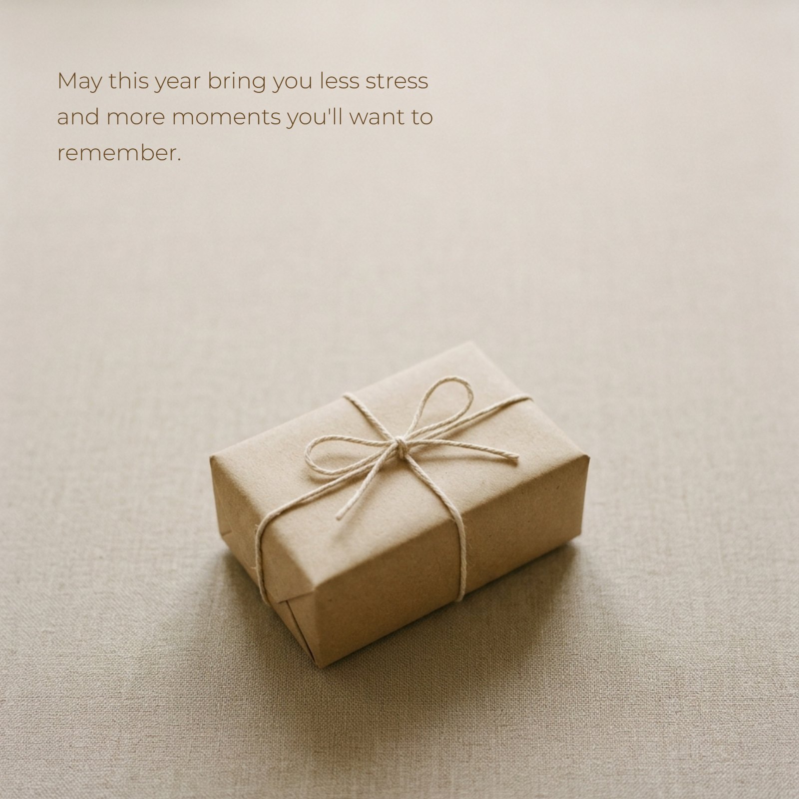 Minimalist photo of a small brown kraft paper gift box tied with twine, overlaid with the text: "May this year bring you less stress and more moments you'll want to remember."