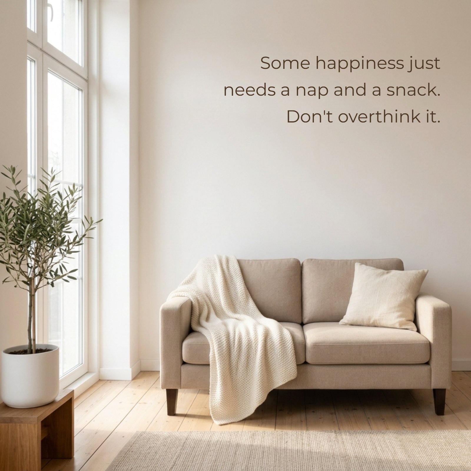A minimalist photo of a cozy beige couch and a textured knit blanket in a sunlit room, with the quote 'Some happiness just needs a nap and a snack. Don't overthink it.' displayed on the pale wall above.