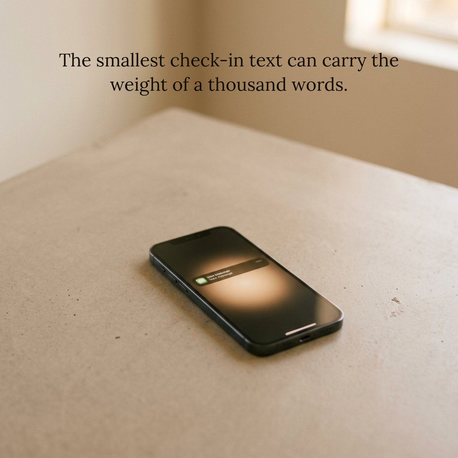 Minimalist image of a smartphone resting face down on a light surface, with a soft amber light glowing underneath it. The quote “The smallest check-in text can carry the weight of a thousand words” is overlaid in a subtle white font.
