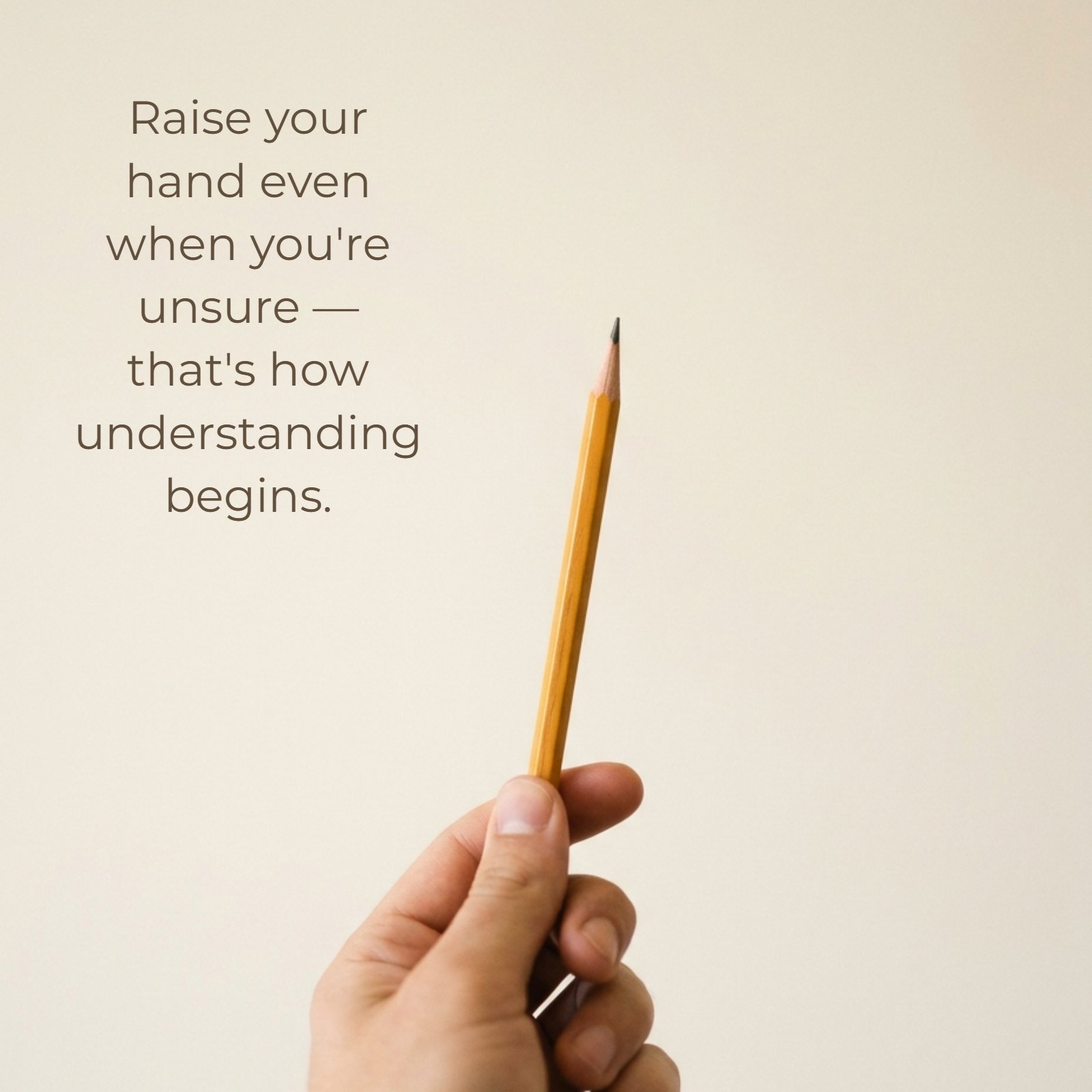 A minimalist photograph shows a single sharpened pencil held vertically by a hand against a plain neutral background with the quote 'Raise your hand even when you're unsure — that's how understanding begins' written on the empty space.