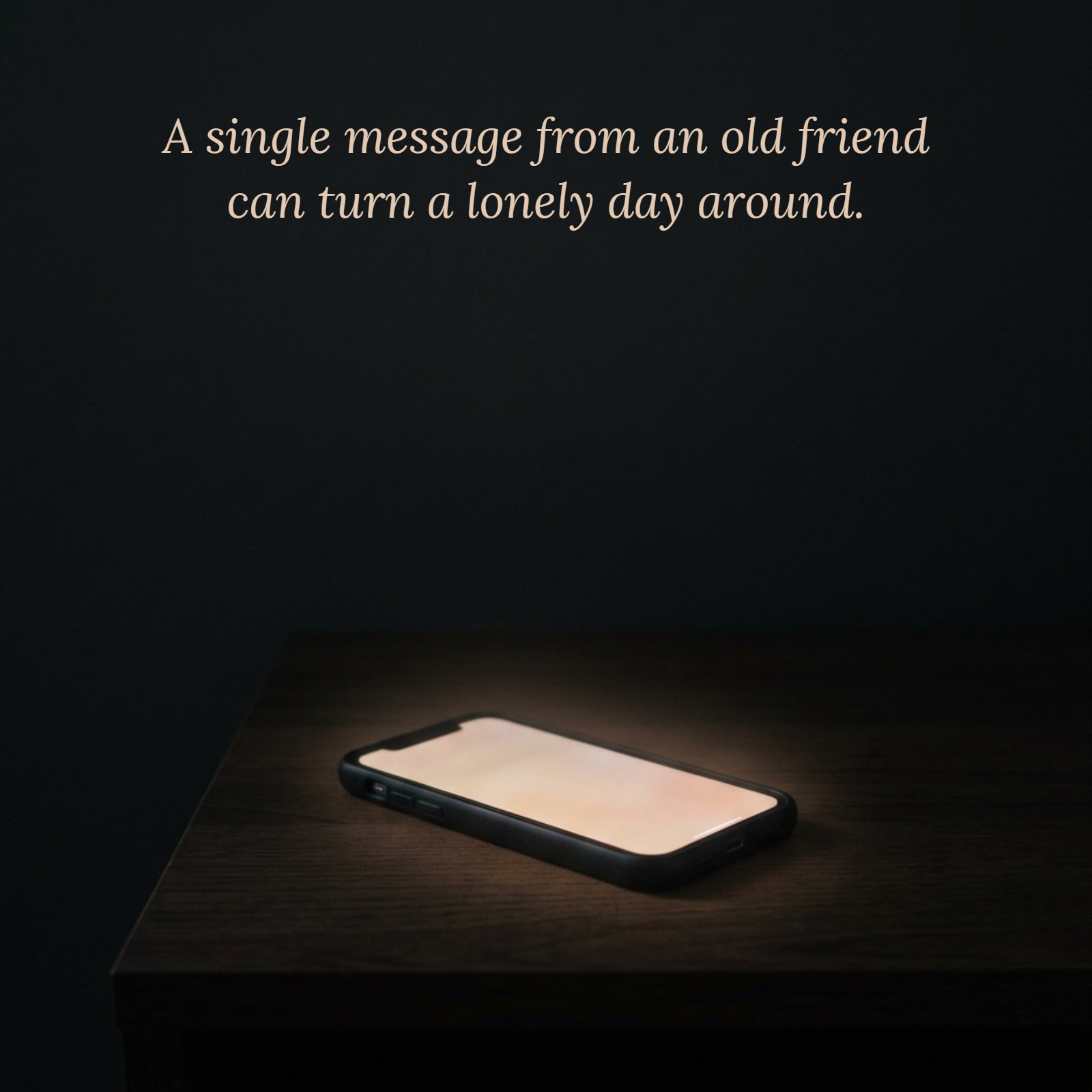 A minimalist photo of a smartphone glowing softly on a dark surface in a dim room, with the quote text on it which reads “A single message from an old friend can turn a lonely day around.”