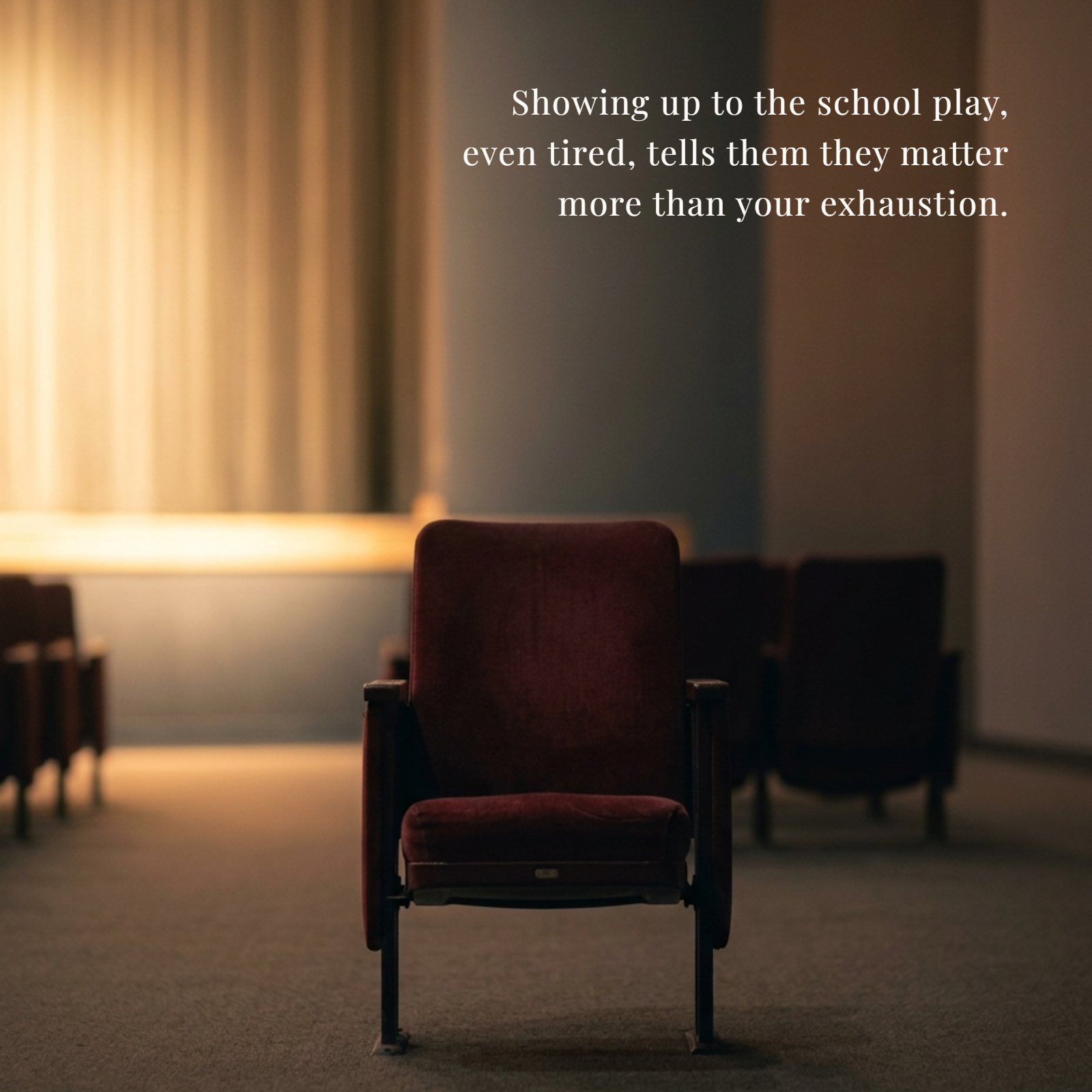 Minimalist image of an empty dark theater seat, glowing with warm stage light from the background, with the inspirational quote on it: Showing up to the school play, even tired, tells them they matter more than your exhaustion.