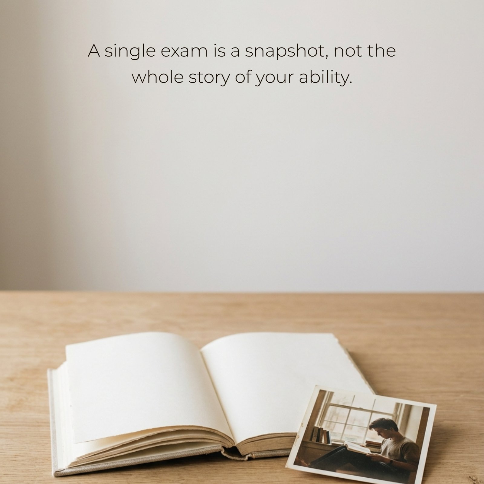 A minimalist scene on a light wood desk featuring an open, blank notebook and a small vintage-style photograph. Superimposed on the empty space above is the motivational quote, A single exam is a snapshot, not the whole story of your ability.