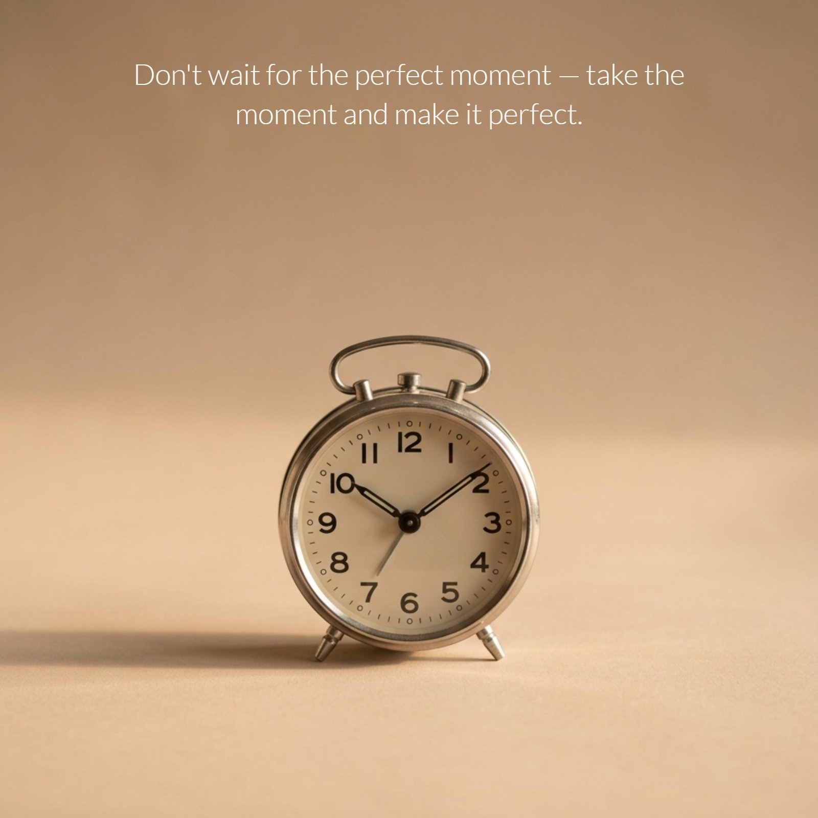 A minimalist photo of a single analog clock resting on a plain, neutral surface with soft, warm side light. The image contains the overlay text: "Don't wait for the perfect moment — take the moment and make it perfect."