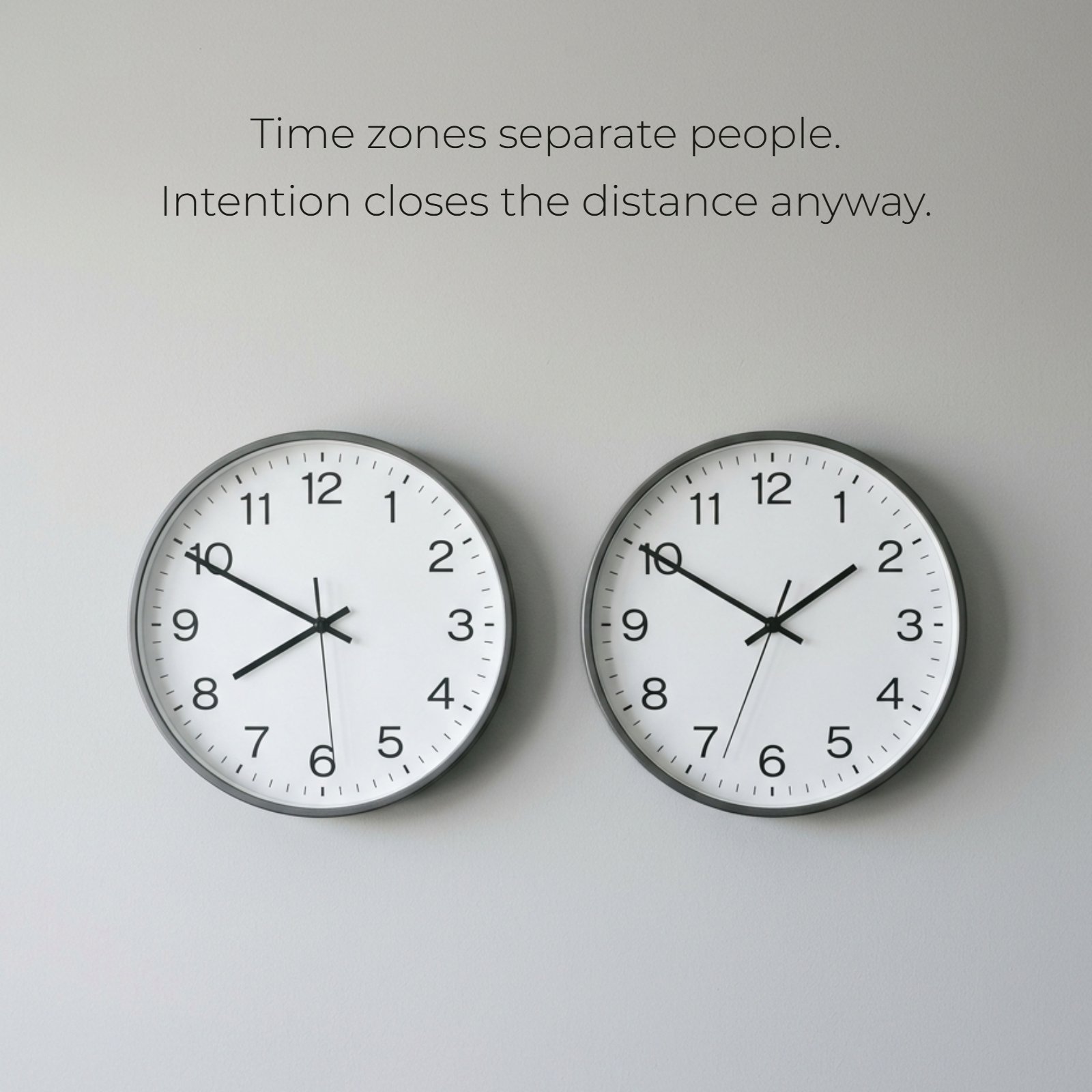 Minimalist image of two analog clocks set to different times on a light grey wall, visually representing the quote "Time zones separate people. Intention closes the distance anyway." about staying connected across different times.