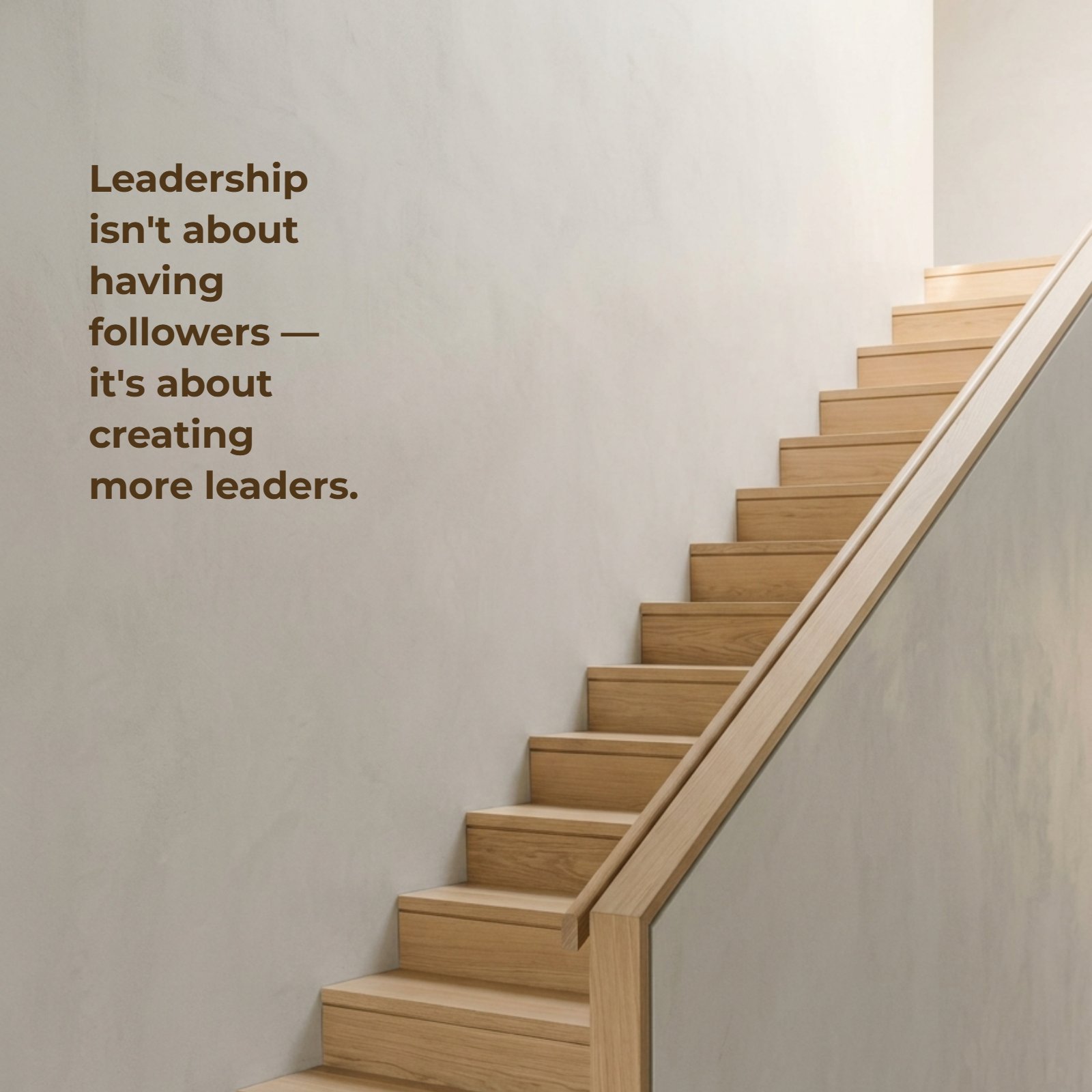 A minimalist photo of modern wooden stairs ascending a neutral grey wall, illuminated by soft warm light, featuring the quote Leadership isn't about having followers — it's about creating more leaders.