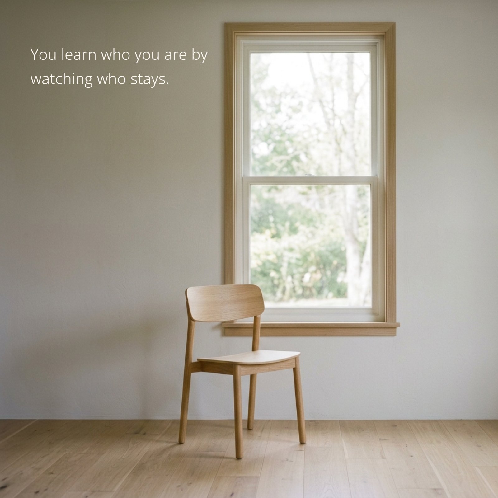 Minimalist photo of a wooden chair next to a large window in a bright room.