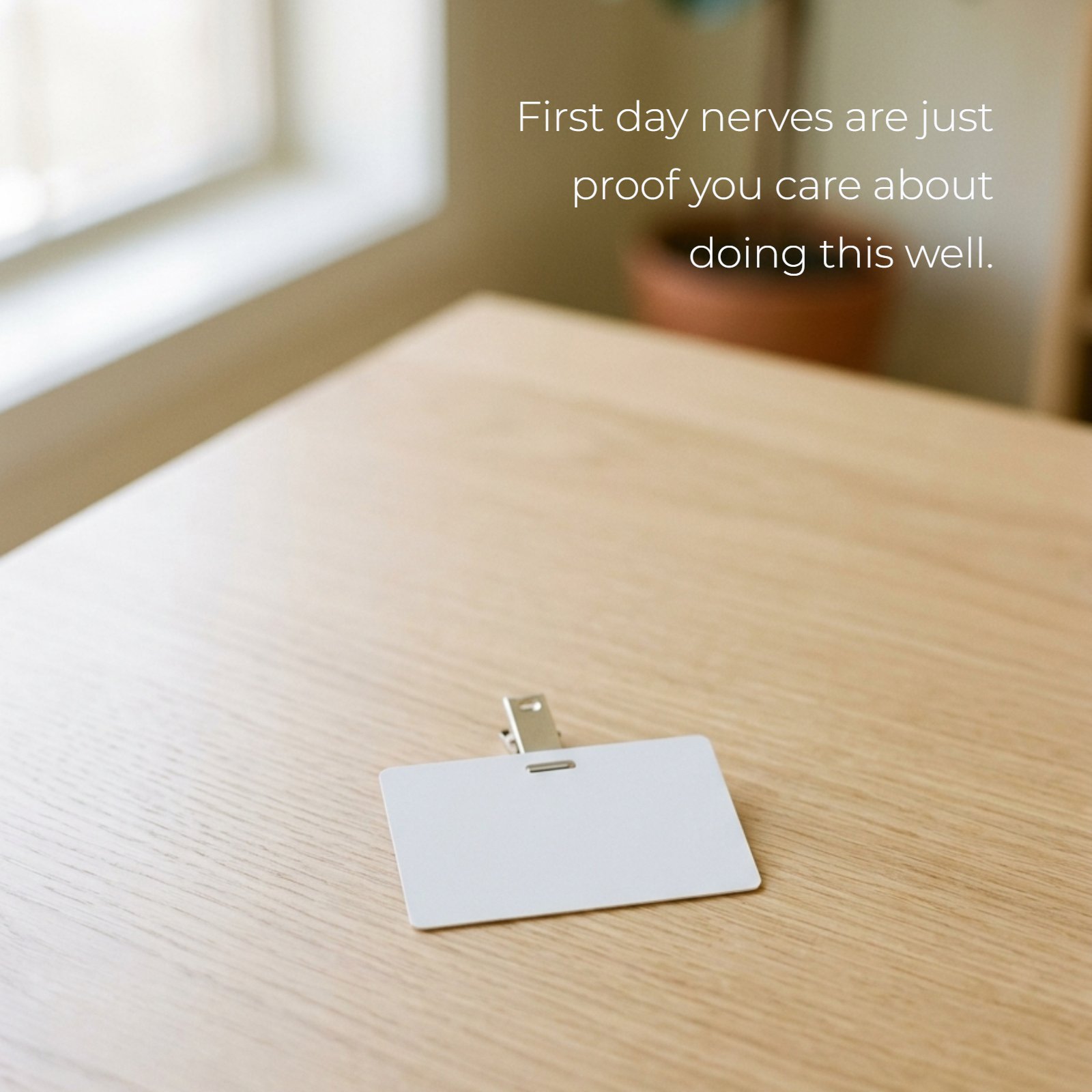 A minimalist photo of a blank office ID badge on a desk, featuring the text overlay: First day nerves are just proof you care about doing this well.